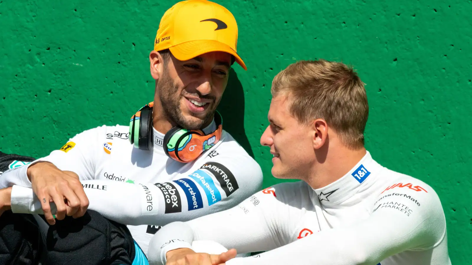 Daniel Ricciardo sitting against the pit wall chatting to Mick Schumacher. Belgium August 2022