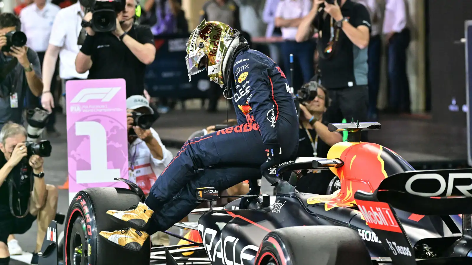 Max Verstappen hops out of his RB18 with the No1 board. Abu Dhabi November 2022