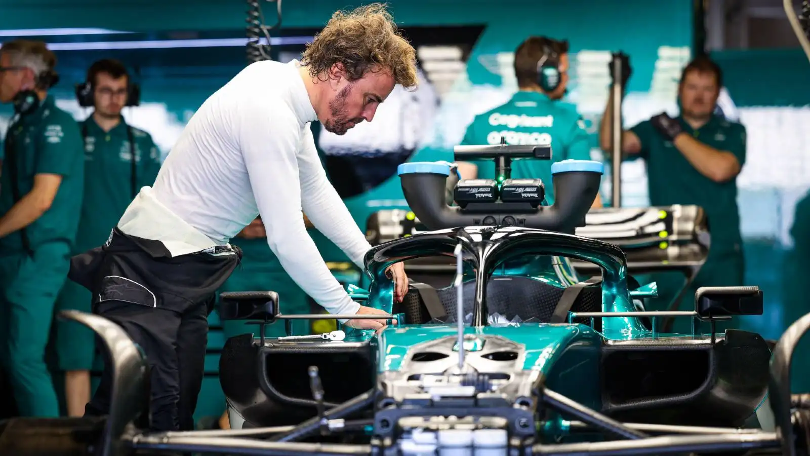 Fernando Alonso leaning over Aston Martin car. Abu Dhabi November 2022.