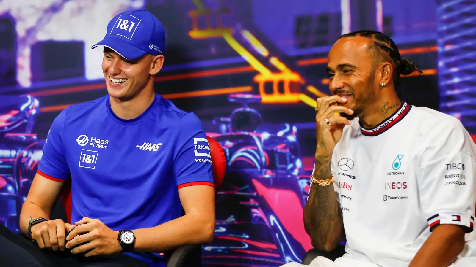 Mick Schumacher smiles next to Lewis Hamilton. Singapore, September, 2022