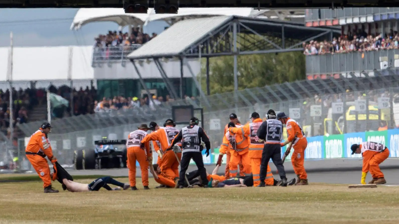 Protestors are dragged away from the Silverstone circuit. Silverstone, July 2022.