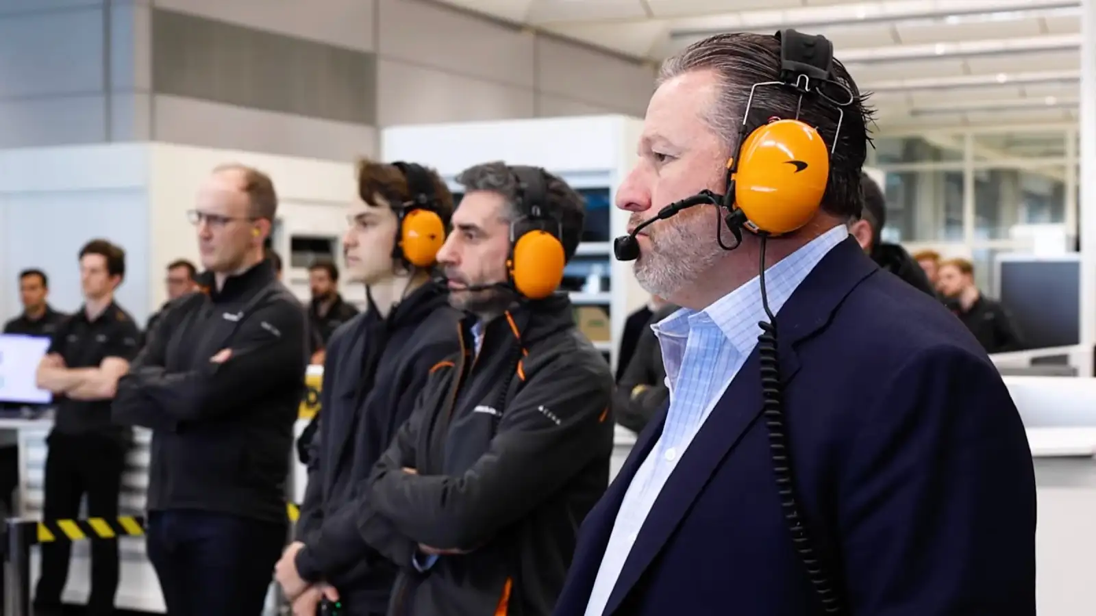 Zak Brown, Andrea Stella and Oscar Piastri watch on as the 2023 McLaren car is fired up. Woking, January 2023.