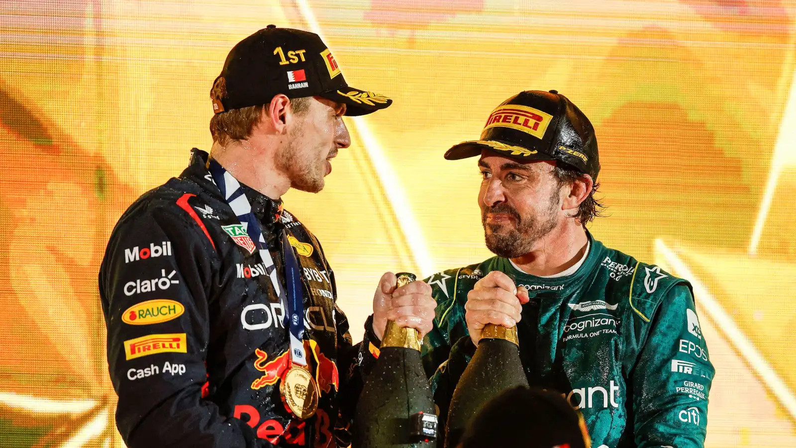 Max Verstappen and Fernando Alonso smiling on the podium with their champagne bottles. Bahrain March 2023