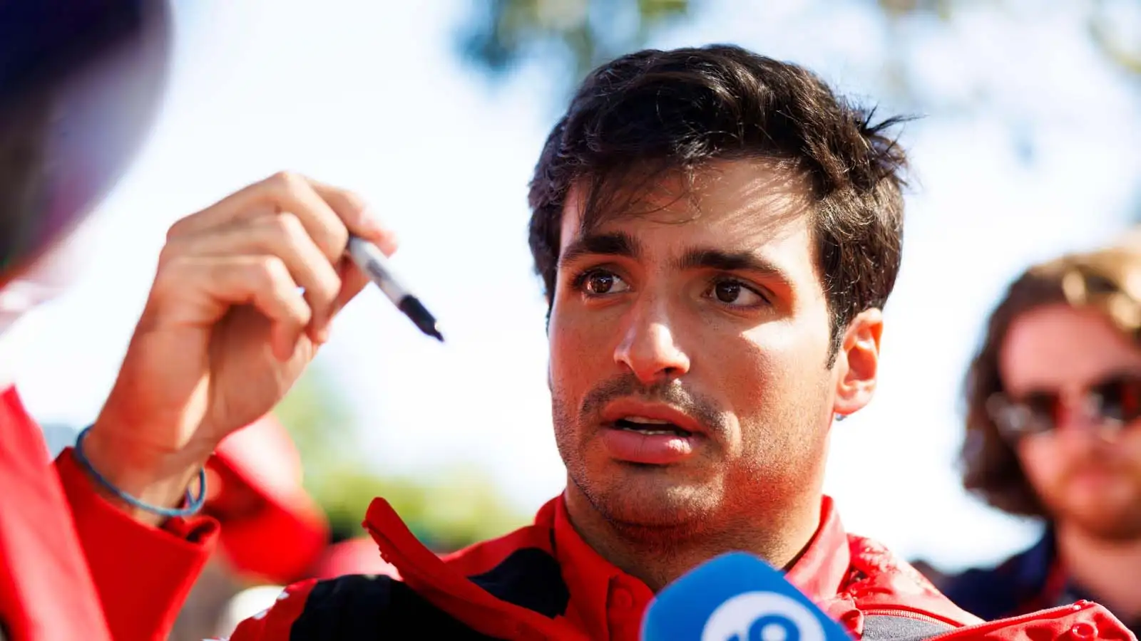 Carlos Sainz signs a Ferrari flag. Australia April 2023.