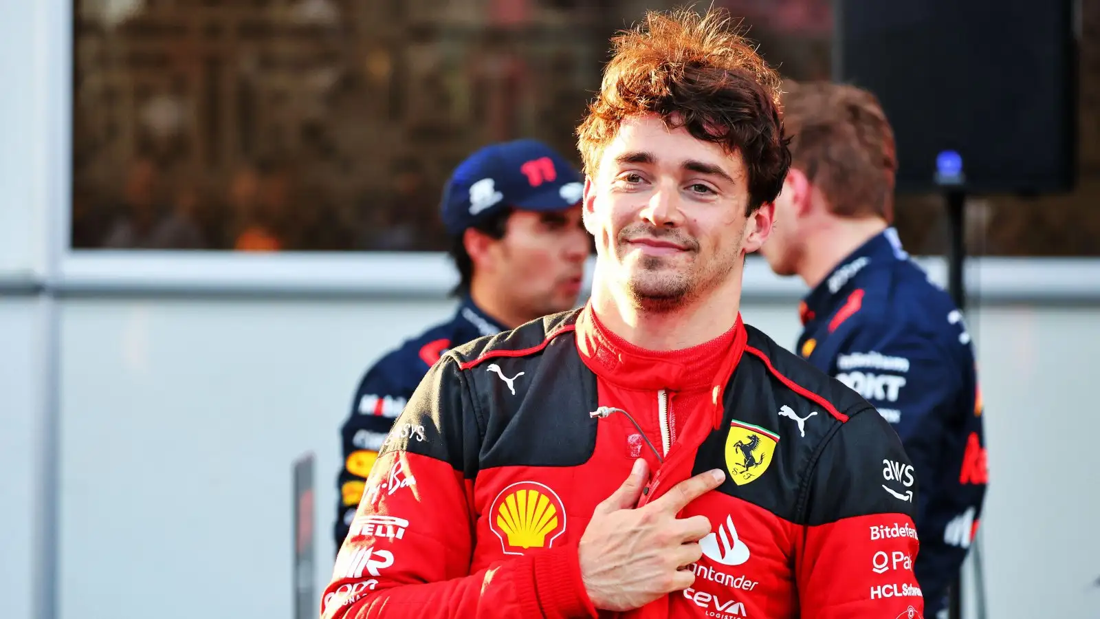 Charles Leclerc points to the Ferrari badge. Baku, April 2023.