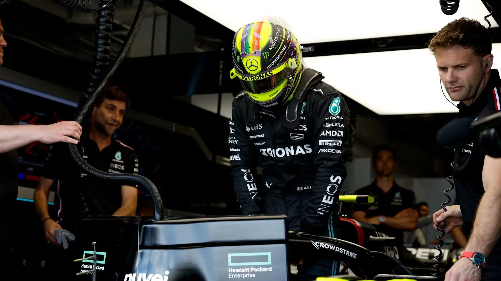 Lewis Hamilton prepares to lower himself into the cockpit of his Mercedes W14 at the Miami Grand Prix. Miami, 2023.