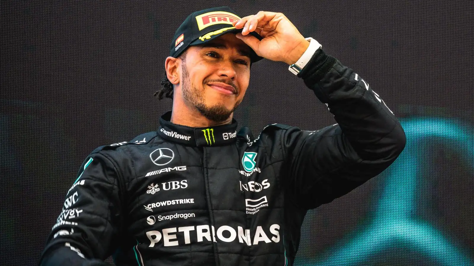 Lewis Hamilton smiling as he adjusts his cap. Barcelona, Spain 2023.