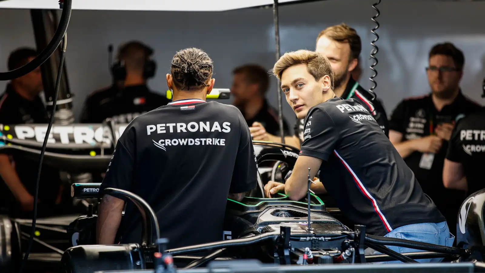 Mercedes driver George Russell looking at the W14 with Lewis Hamilton.