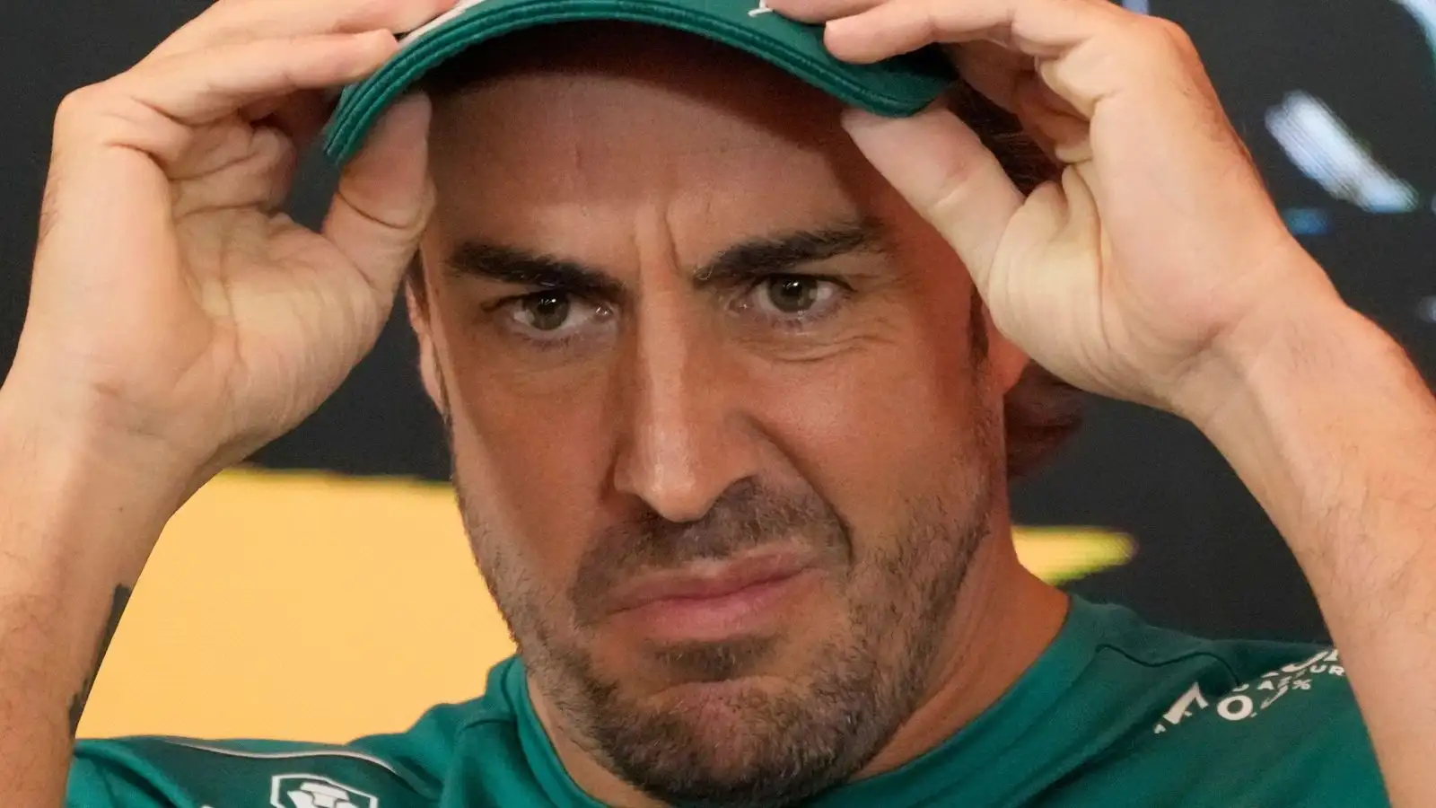 Fernando Alonso adjusts his cap during a press conference.