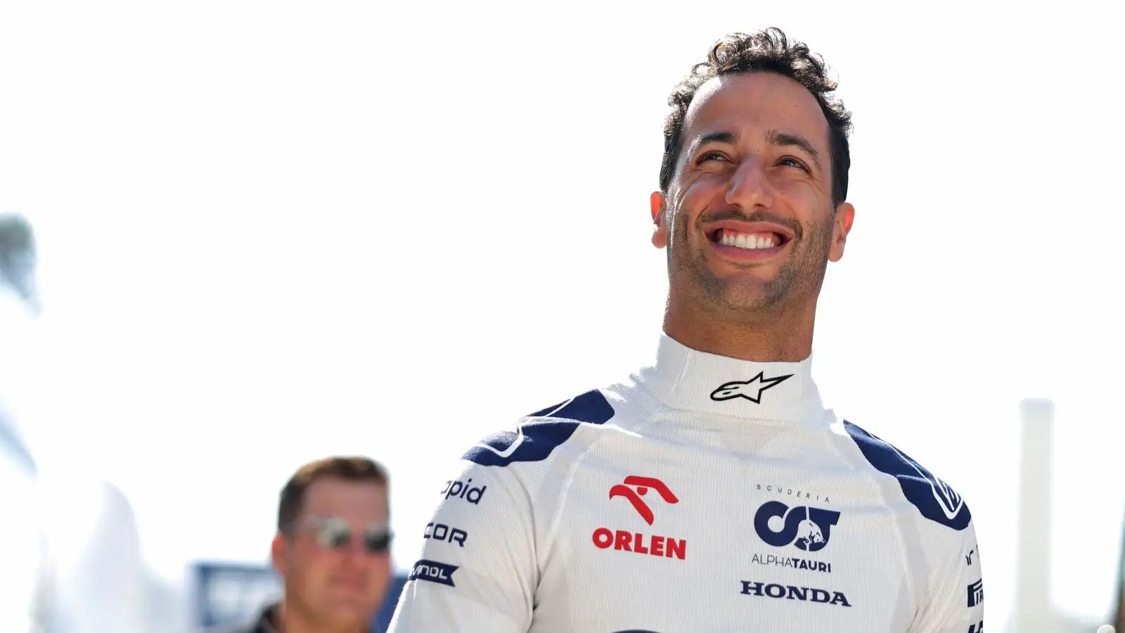Daniel Ricciardo smiles as he walks through the paddock ahead of his F1 return with AlphaTauri at the Hungarian Grand Prix. Budapest, July 2023.
