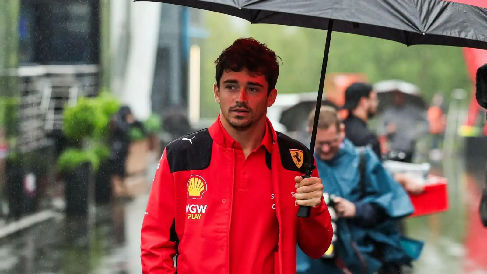 Charles Leclerc holds an umbrella. Spa July 2023.