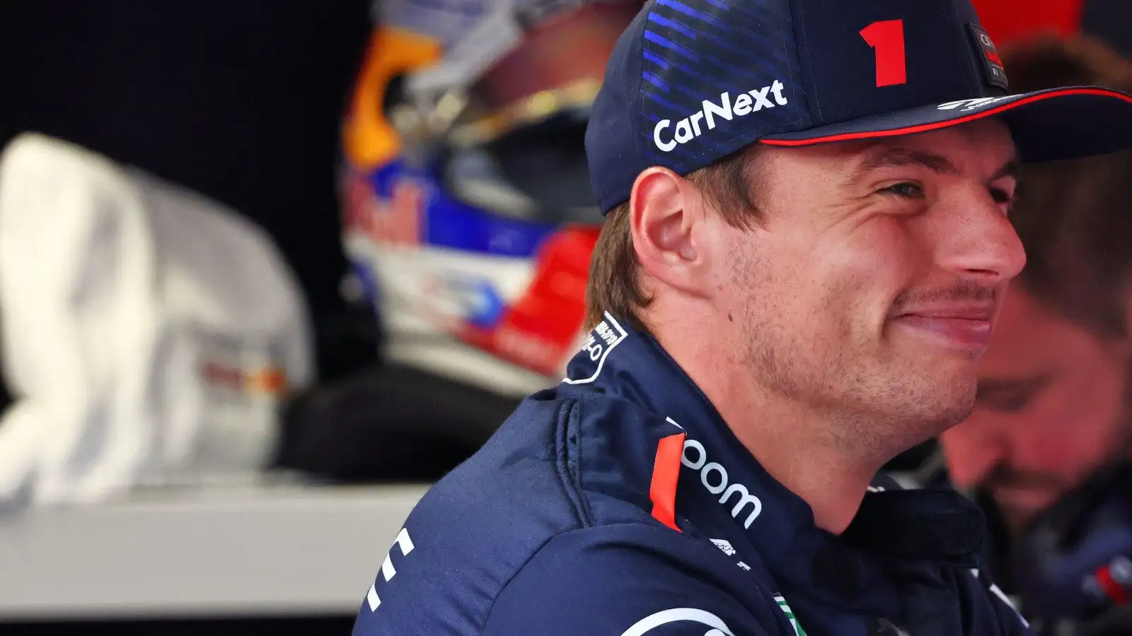 Reigning World Champion Max Verstappen grinning in the Red Bull garage.