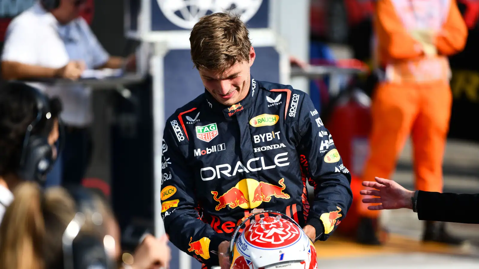 Red Bull driver Max Verstappen smiling as he puts his helmet down after another good session.