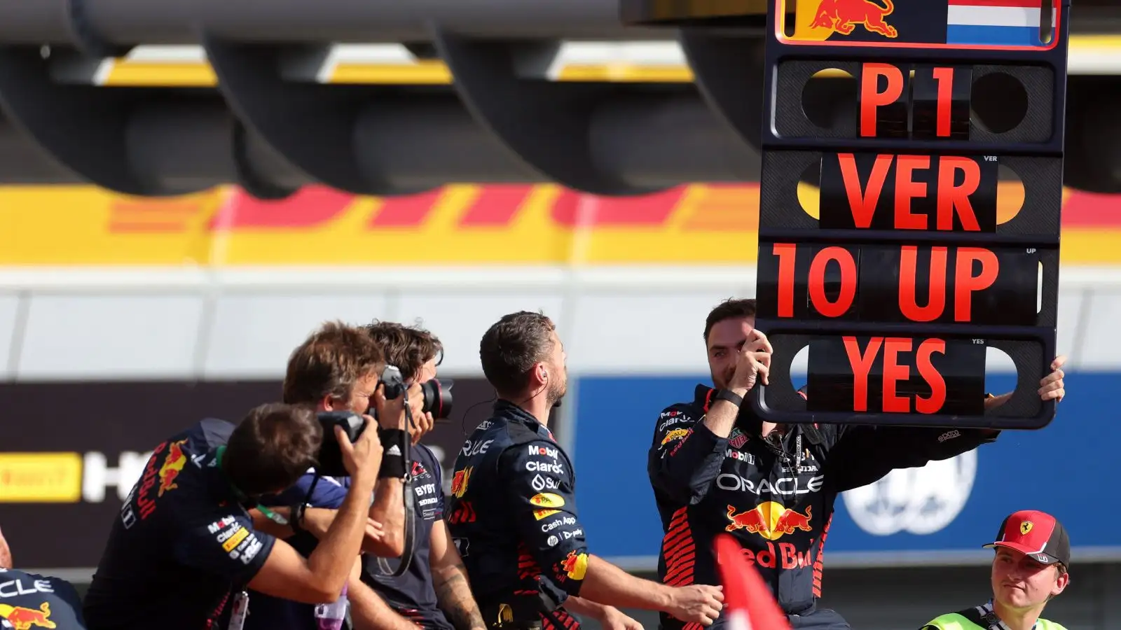 Red Bull mechanic holds up a pit board celebrating Max Verstappen's 10th successive win, a new F1 record.