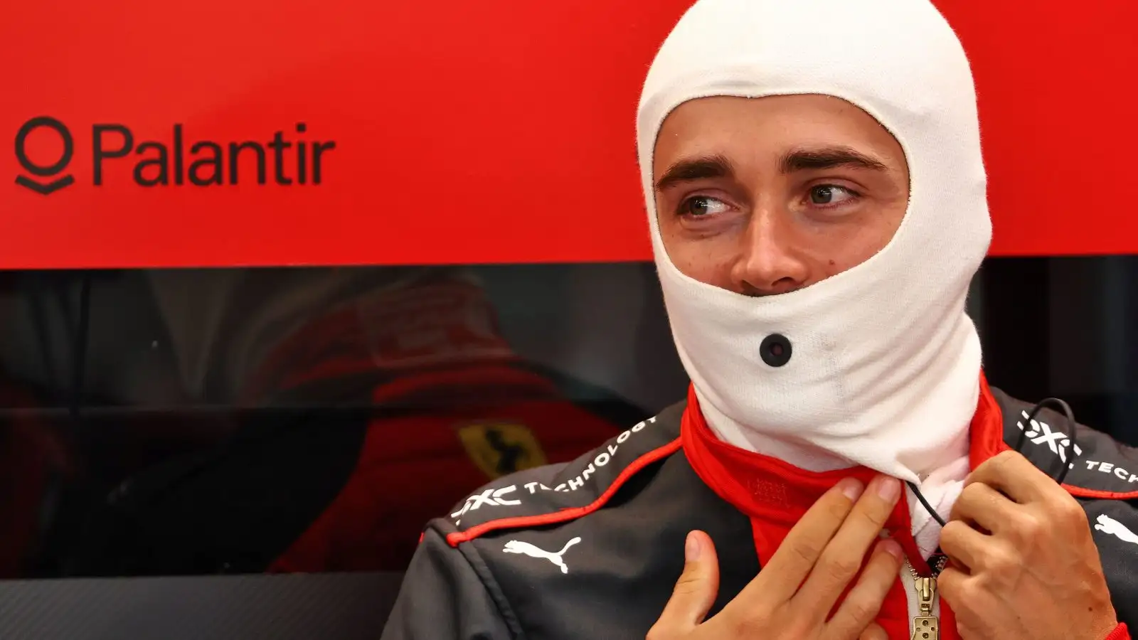 Ferrari driver Charles Leclerc putting on his fireproofs in the Ferrari garage.