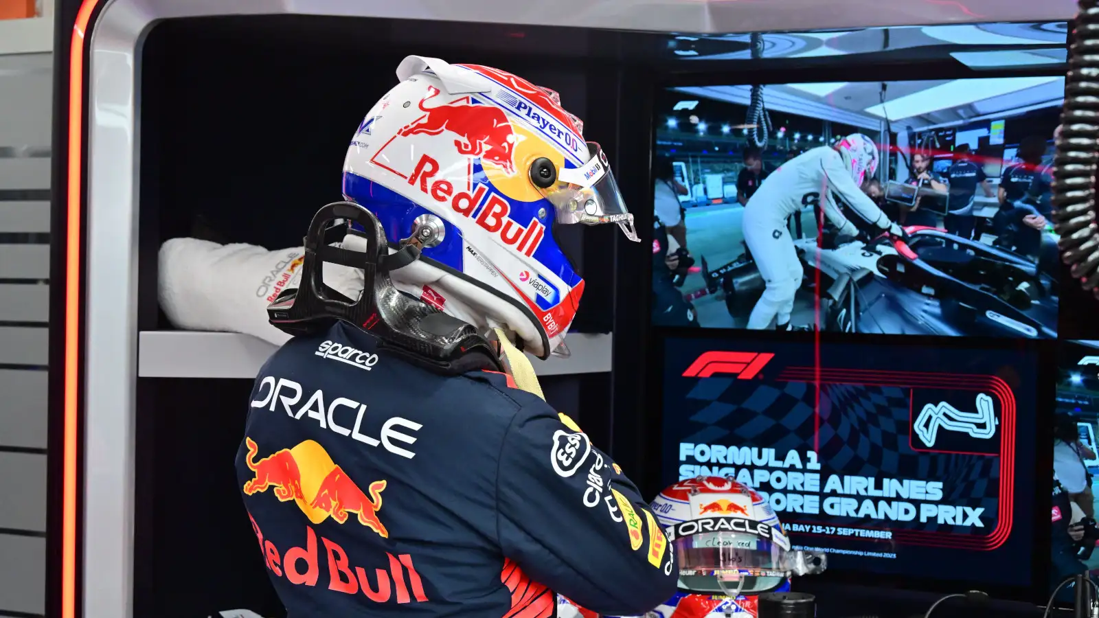 Max Verstappen watching Liam Lawson on the screen in Singapore.