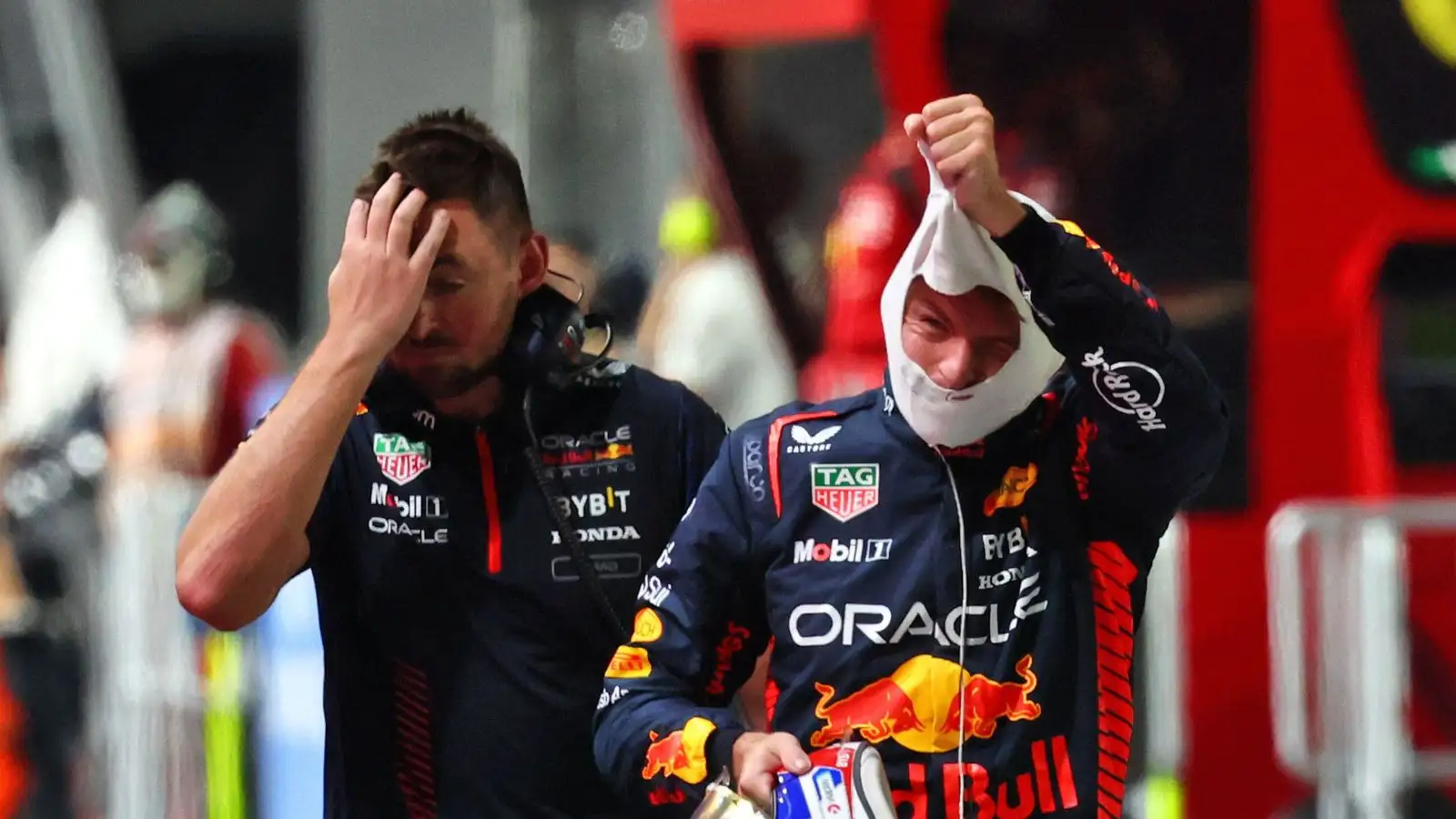 Max Verstappen pulls off his fireproofs after exiting qualifying in Singapore.