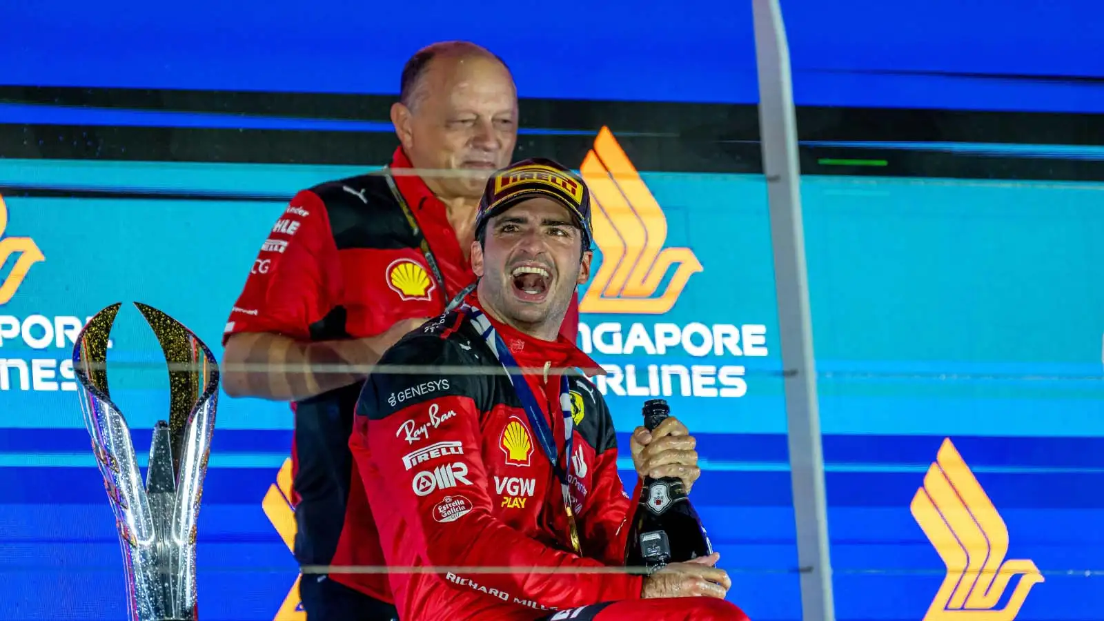 Ferrari driver Carlos Sainz on the podium with team boss Fred Vasseur.