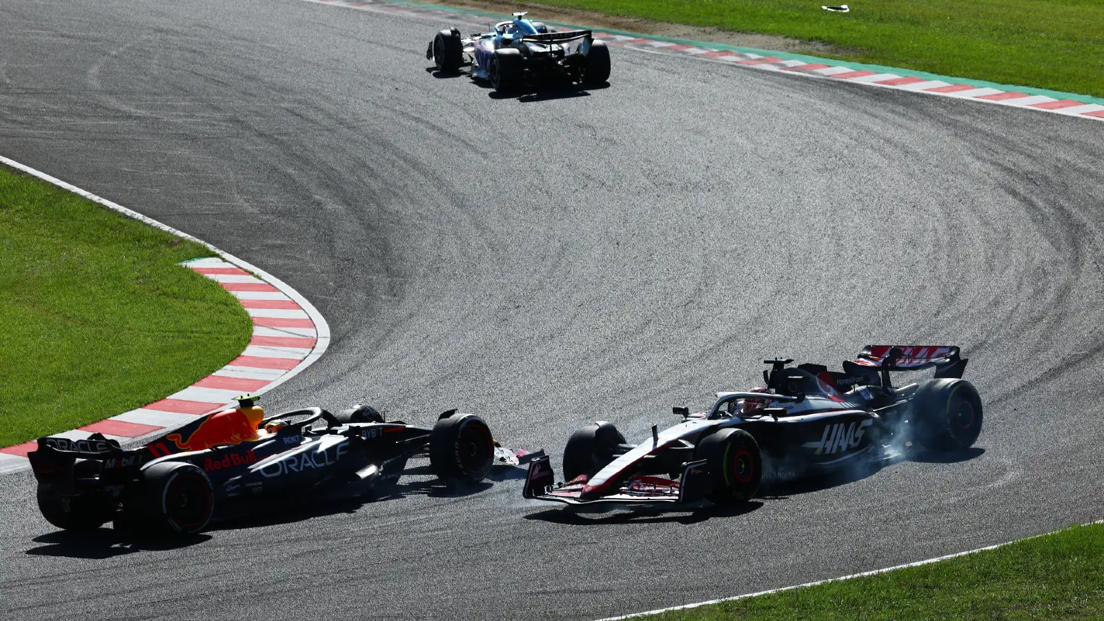 Haas driver Kevin Magnussen gets spun around by Red Bull's Sergio Perez during the Japanese Grand Prix.