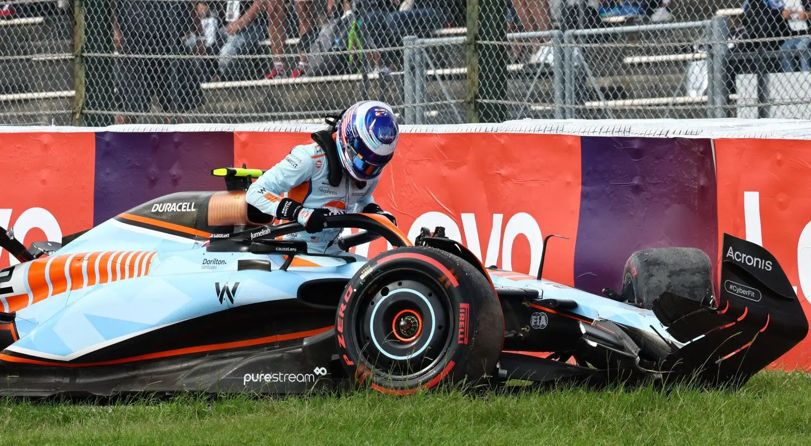 Williams driver Logan Sargeant climbs out of his crashed Williams.