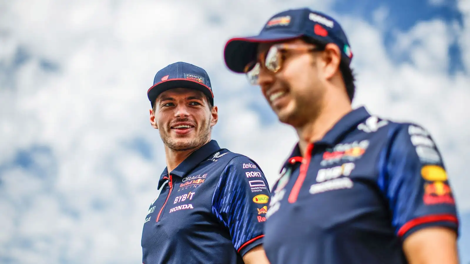 Red Bull drivers Max Verstappen and Sergio Perez walk and share a joke at the 2023 Japanese Grand Prix.