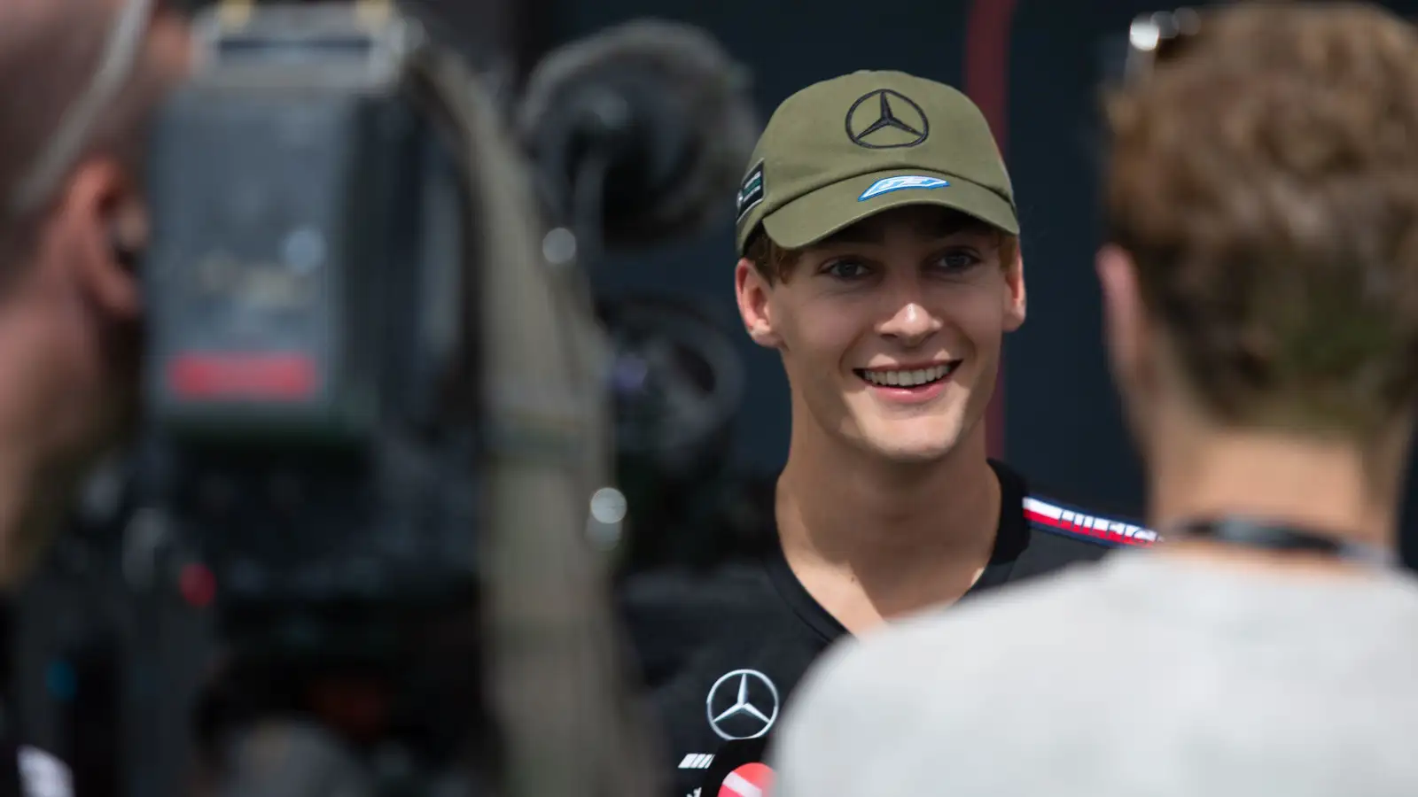Mercedes driver George Russell gives an interview in the paddock.