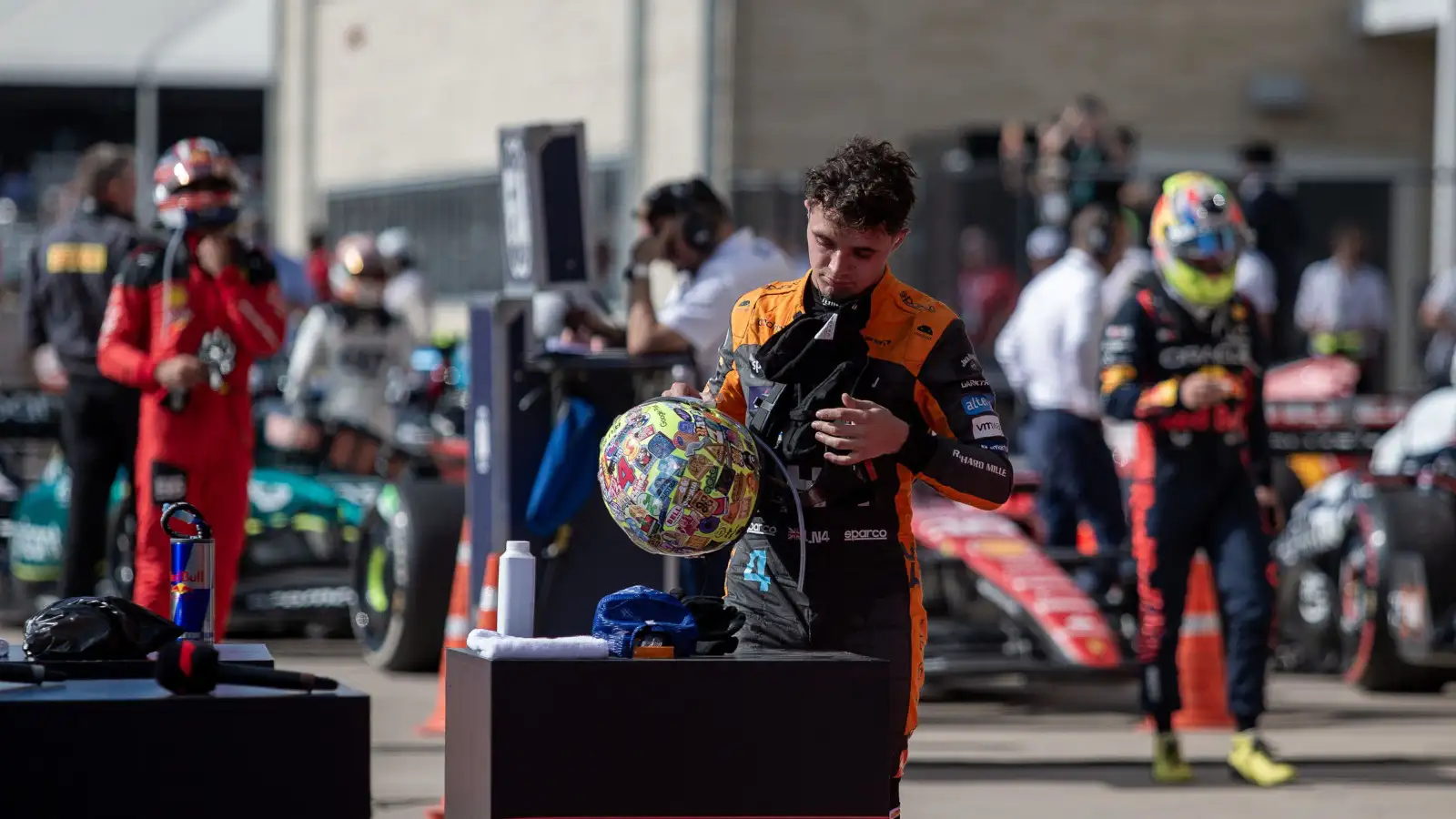 McLaren driver Lando Norris puts his helmet down before speaking in the post-race interview.