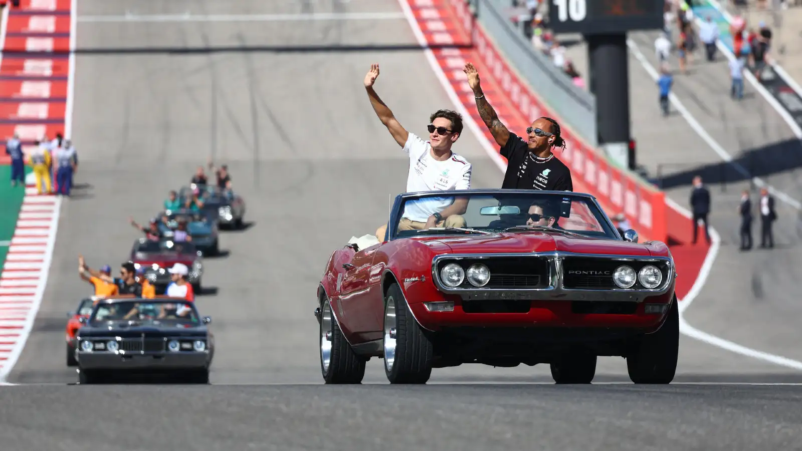 The vintage car drivers' parade at the United States Grand Prix, with Mercedes drivers George Russell and Lewis Hamilton.
