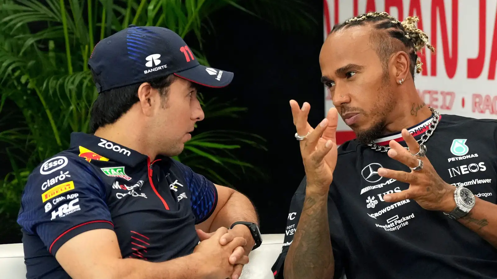 Red Bull driver Sergio Perez chatting with Lewis Hamilton during a press conference.