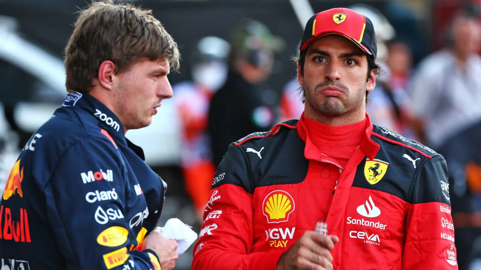 Ferrari driver Carlos Sainz pulls a face while speaking with Max Verstappen.