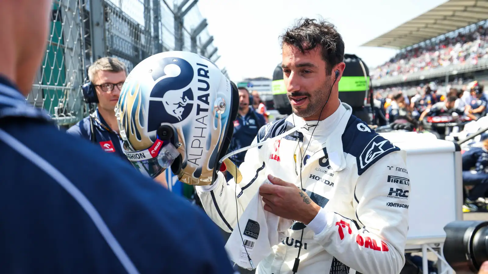 AlphaTauri driver Daniel Ricciardo putting on his helmet on the grid.