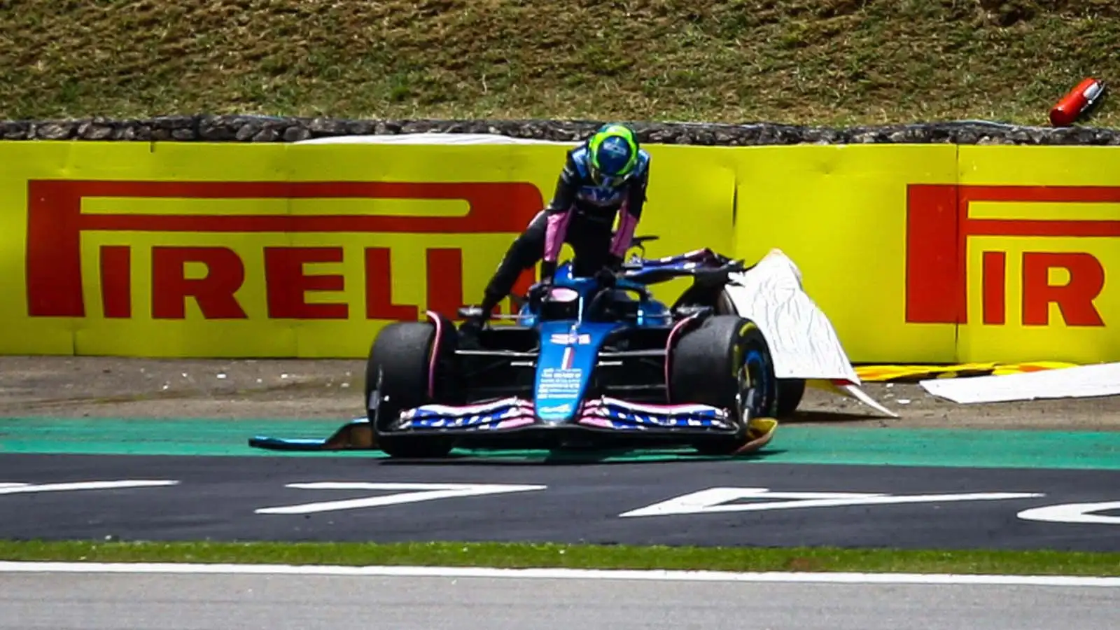 Esteban Ocon climbs from his car after colliding with Fernando Alonso.