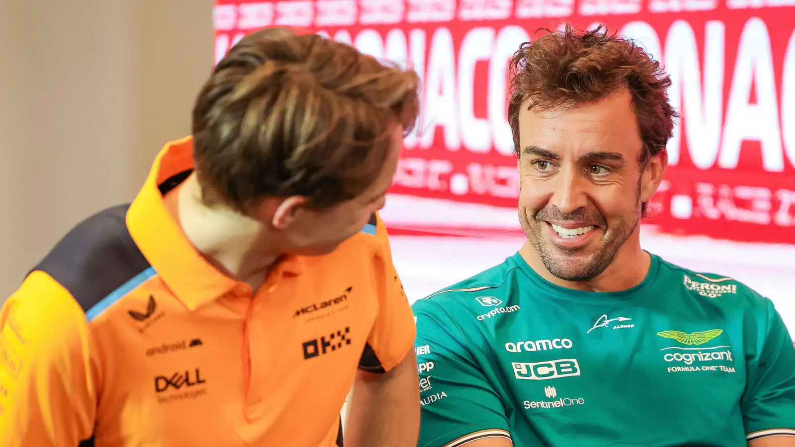 McLaren driver Oscar Piastri turns to look at Fernando Alonso.