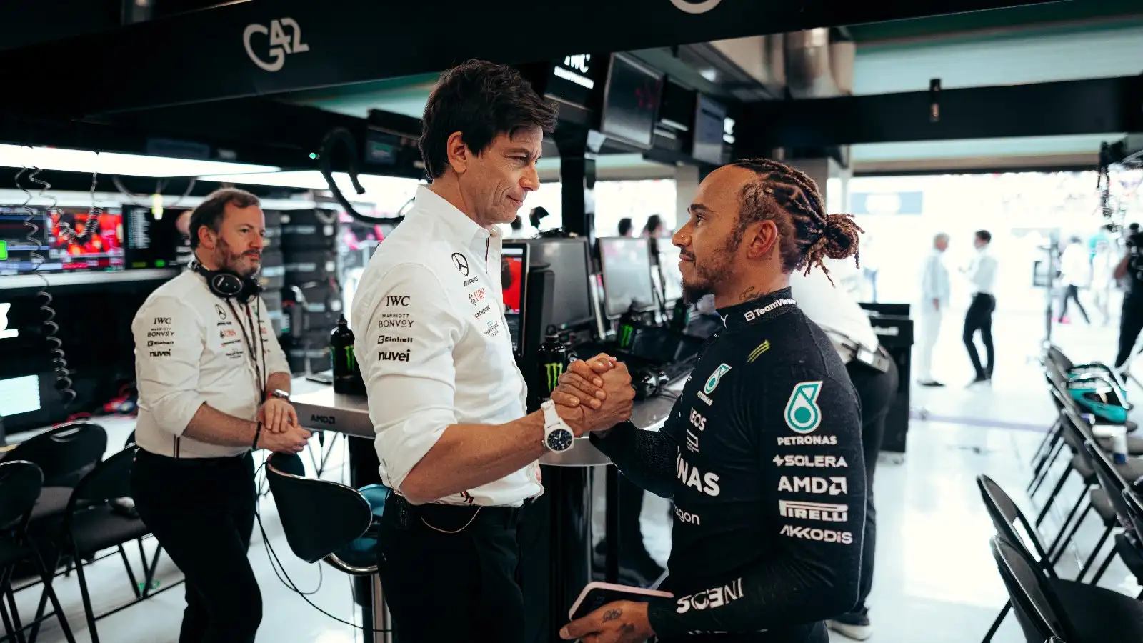 Toto Wolff shakes hands with Lewis Hamilton.