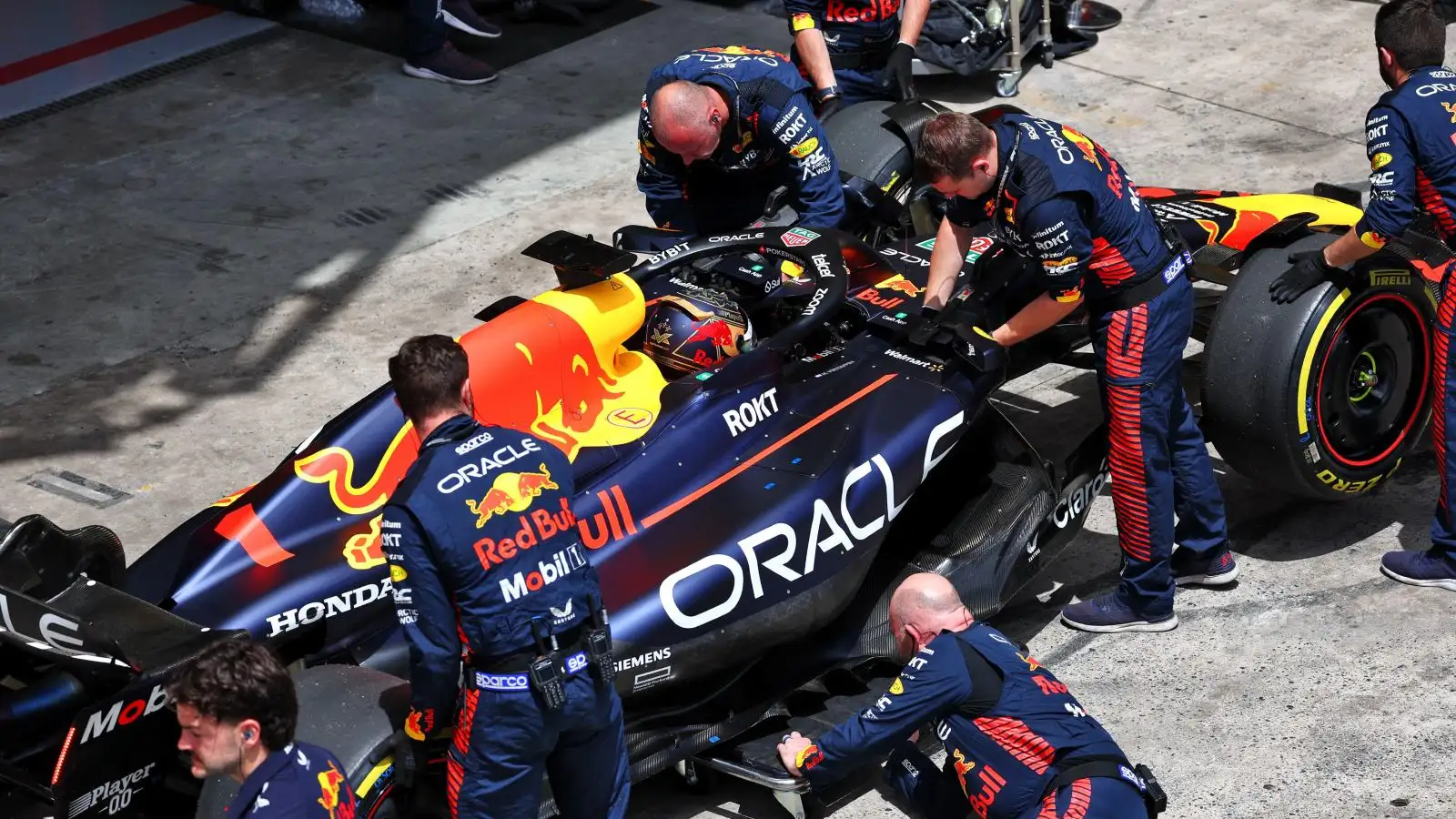 Red Bull mechanics apply the finishing touches to Max Verstappen's Red Bull car in São Paulo.