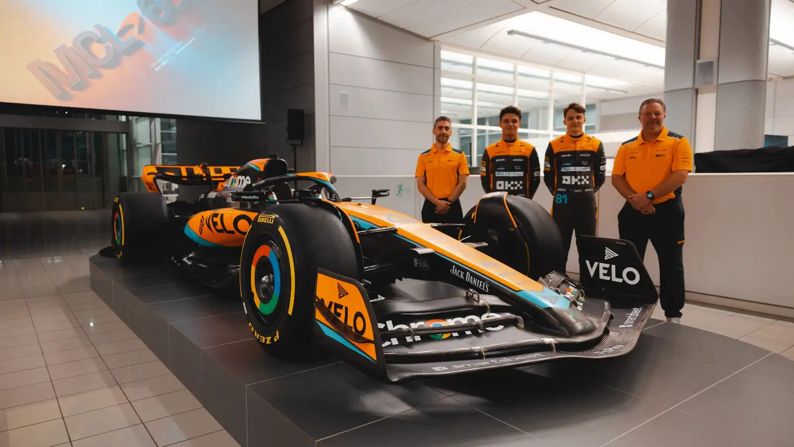 The McLaren 2023 car with Andrea Stella, Lando Norris, Oscar Piastri and Zak Brown.