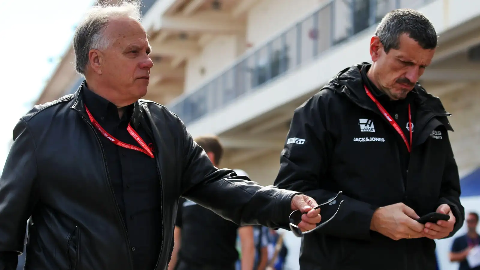 Gene Haas and Guenther Steiner walk together in the Formula 1 paddock.