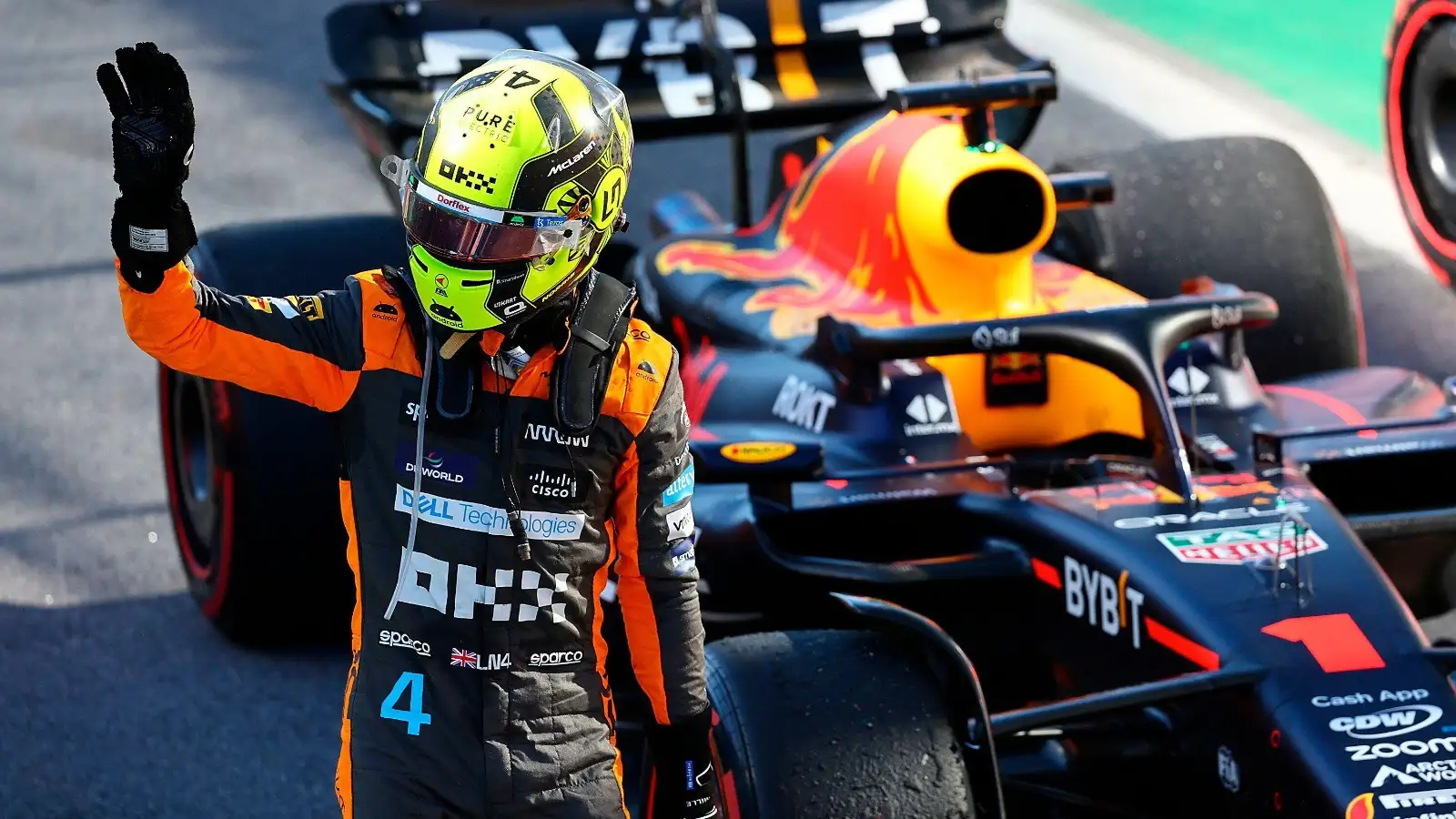 Lando Norris waves in front of the Red Bull.