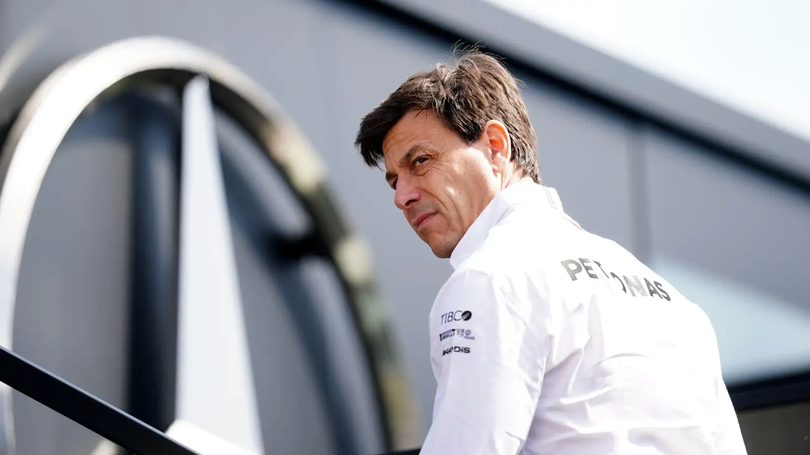 Toto Wolff with the Mercedes logo behind him.