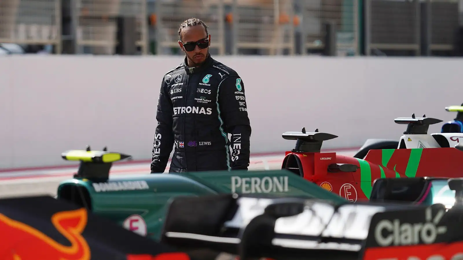 Lewis Hamilton looks at Charles Leclerc's Ferrari.
