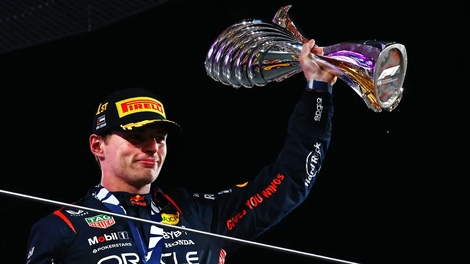 Max Verstappen lifts a trophy.