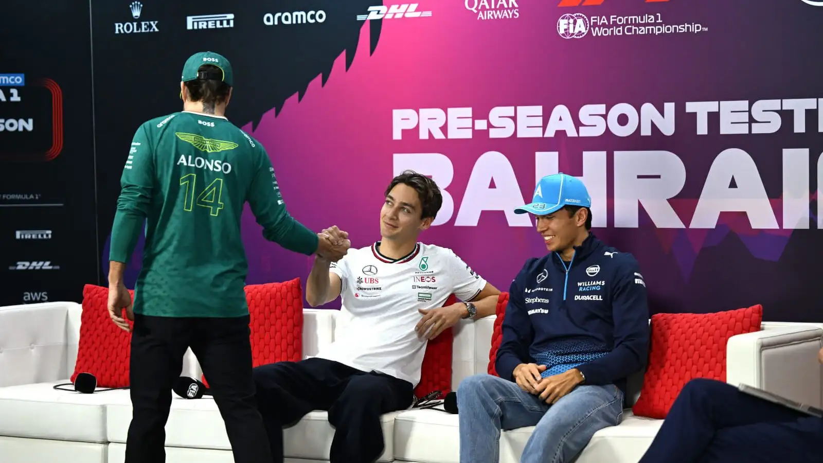 Fernando Alonso shakes hands with George Russell and Alex Albon