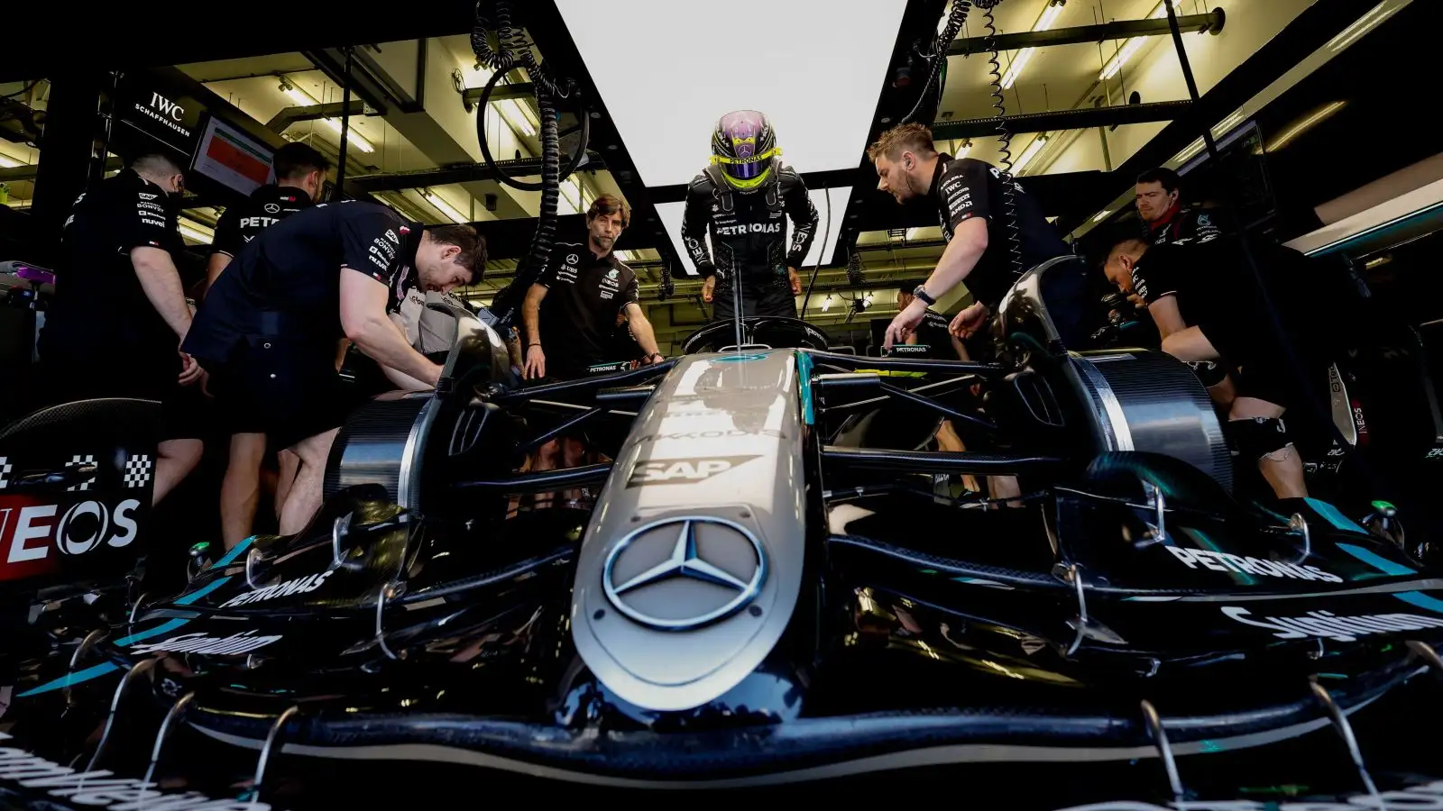 Lewis Hamilton climbs into his W15 in the Mercedes garage during F1 2024 winter testing