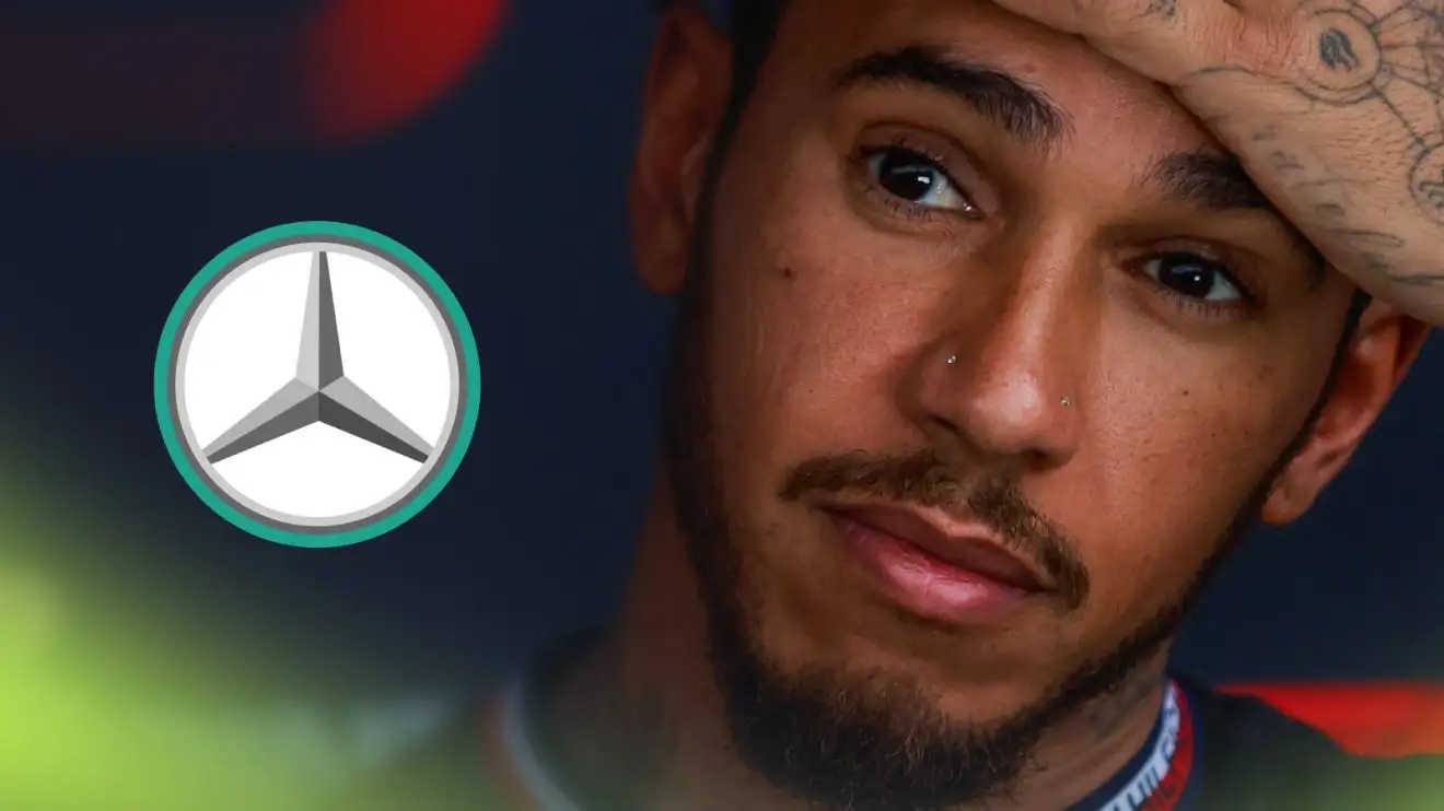 Lewis Hamilton wipes his forehead with a prominent Mercedes logo alongside him