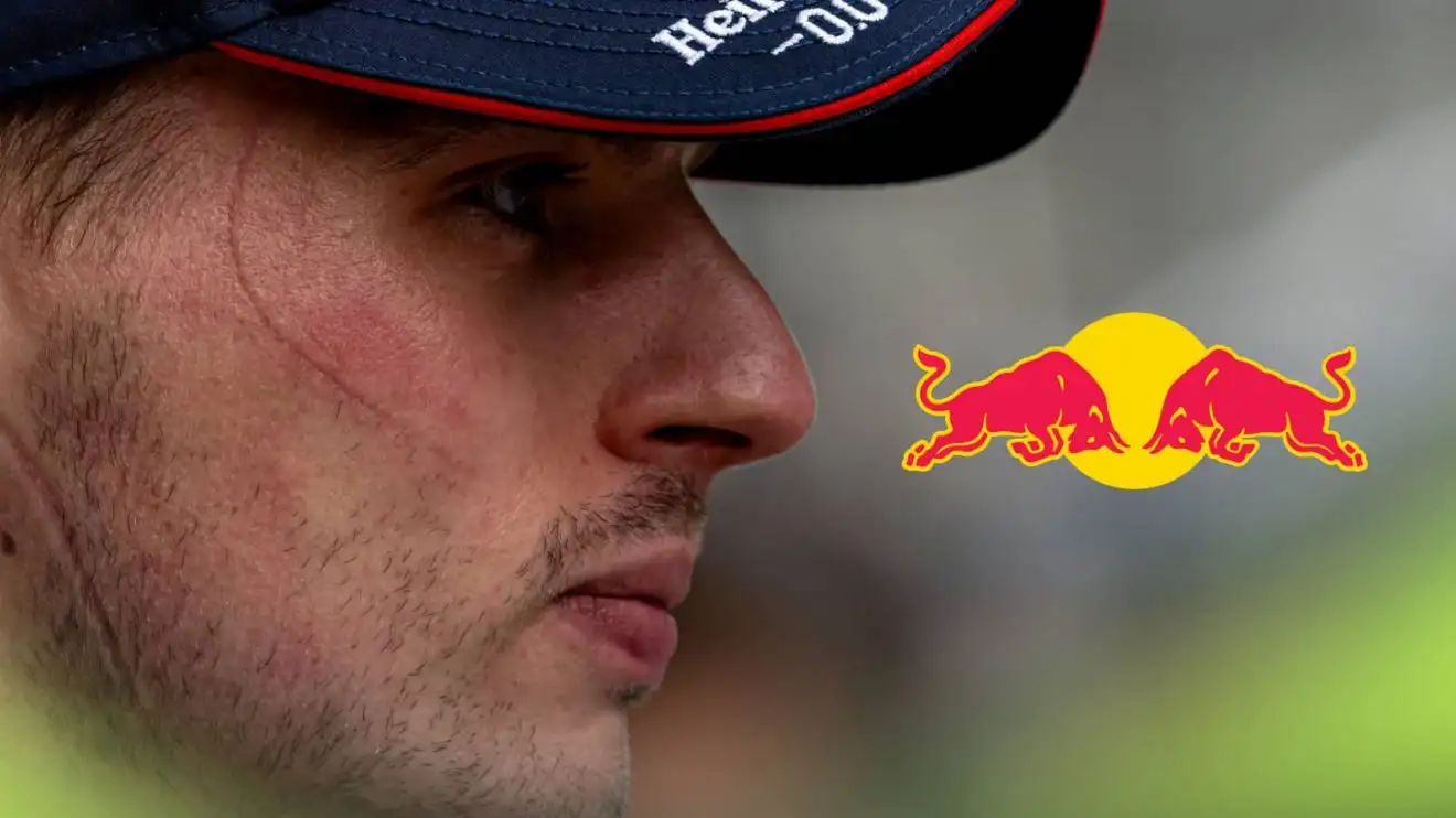 A side-profile shot of Max Verstappen with a prominent Red Bull logo alongside him
