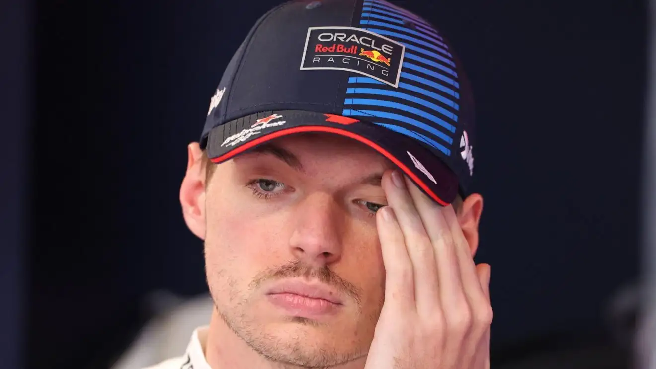 Red Bull's Max Verstappen with his hand to his face.