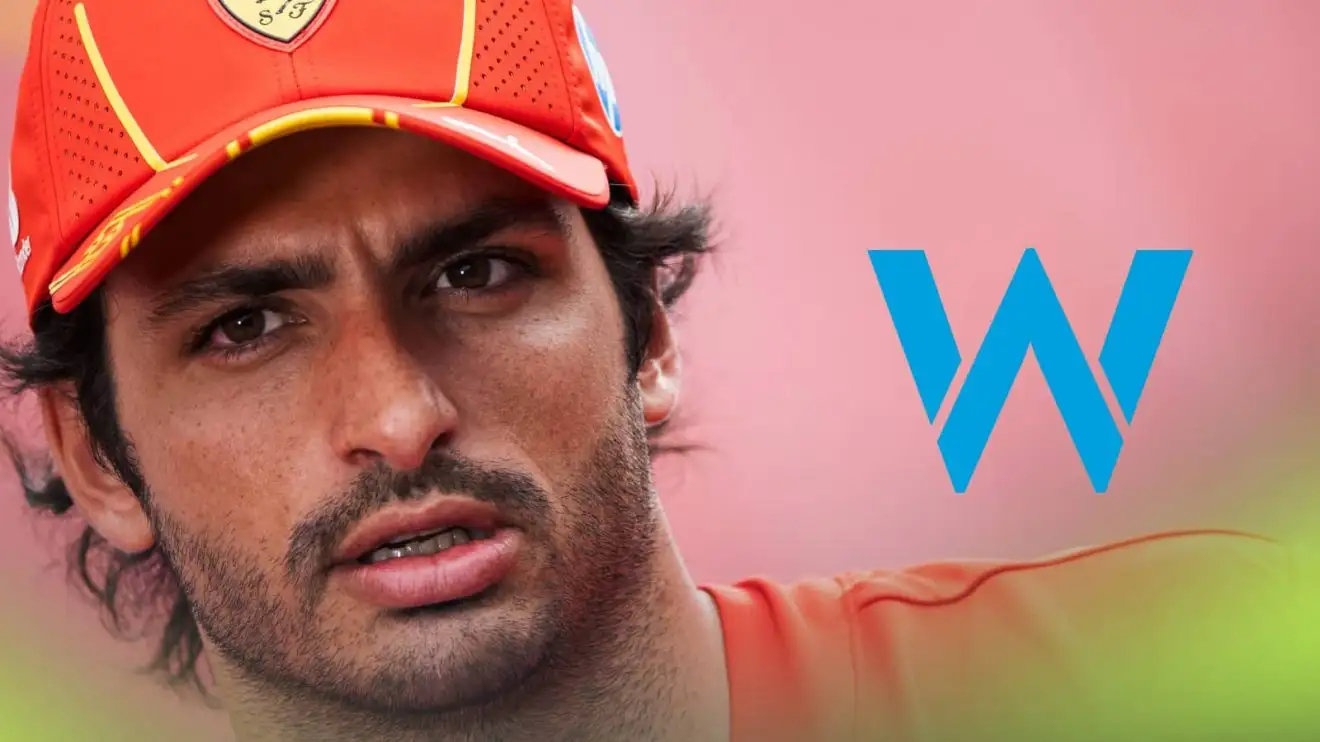 A close-up shot of Carlos Sainz with a prominent Williams logo alongside him