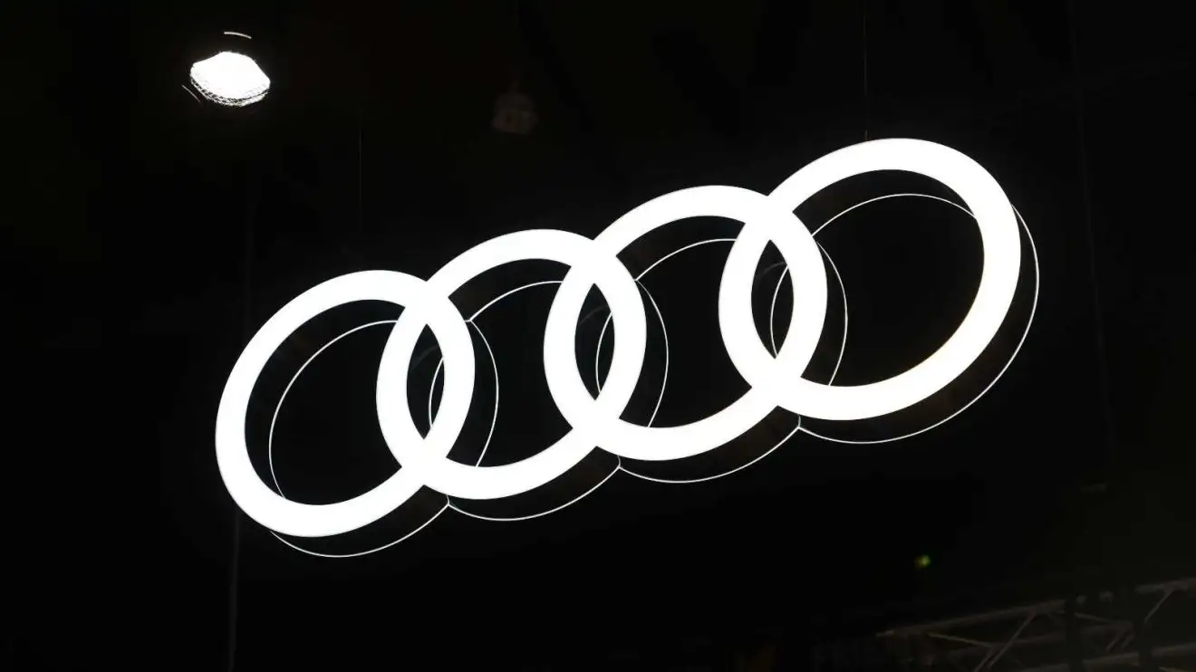 Audi's logo illuminated against the night sky