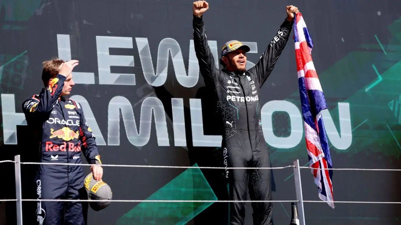 Max Verstappen and Lewis Hamilton on the podium after Hamilton wins the 2024 British Grand Prix.