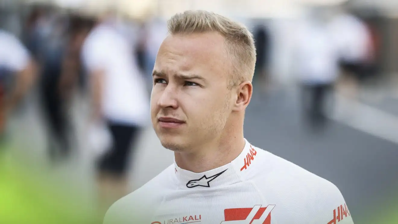 Nikita Mazepin glances up as he walks down the pit lane